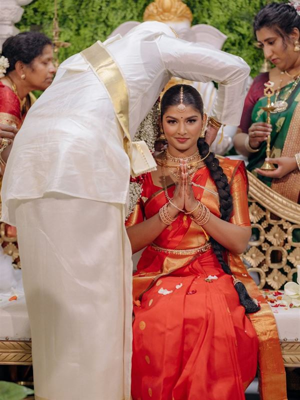Bride in a red sari with folded hands during the Hindu ceremony
