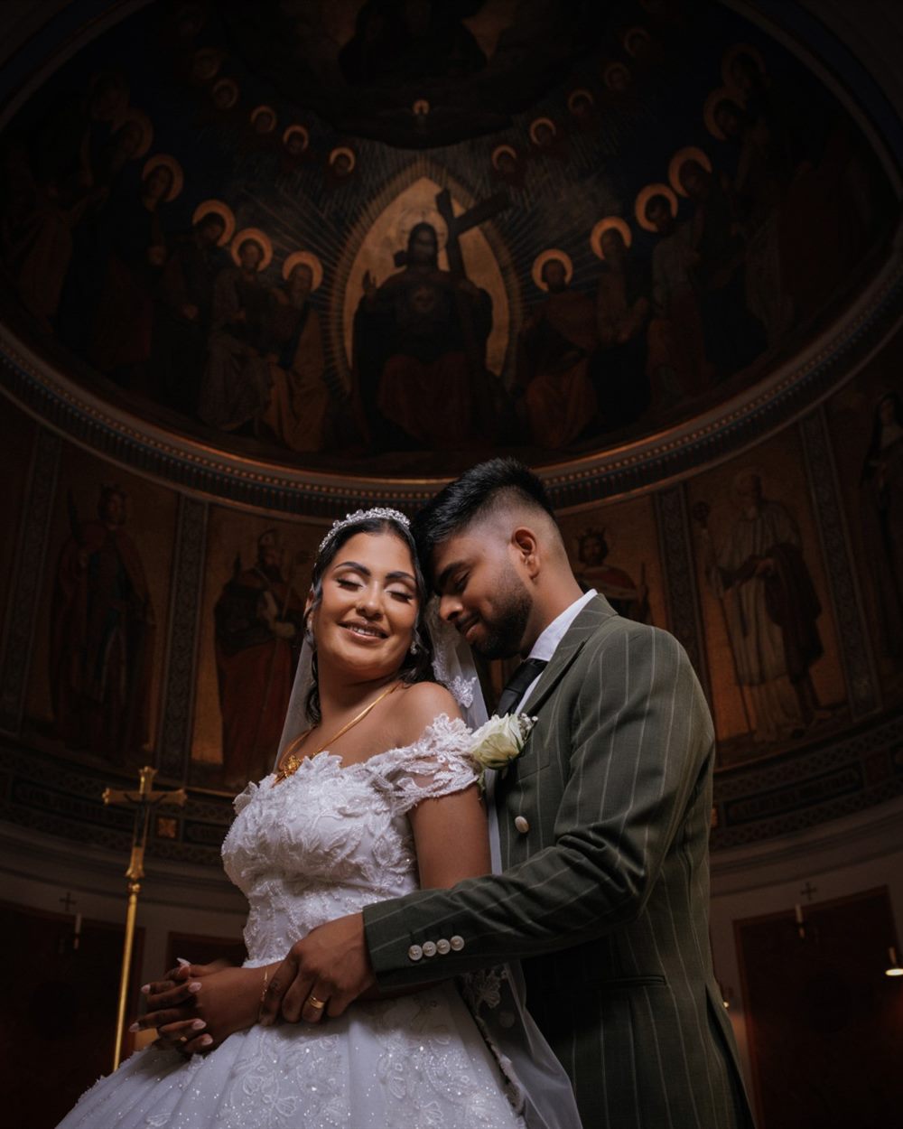 Bride and groom close together before the altar in a church